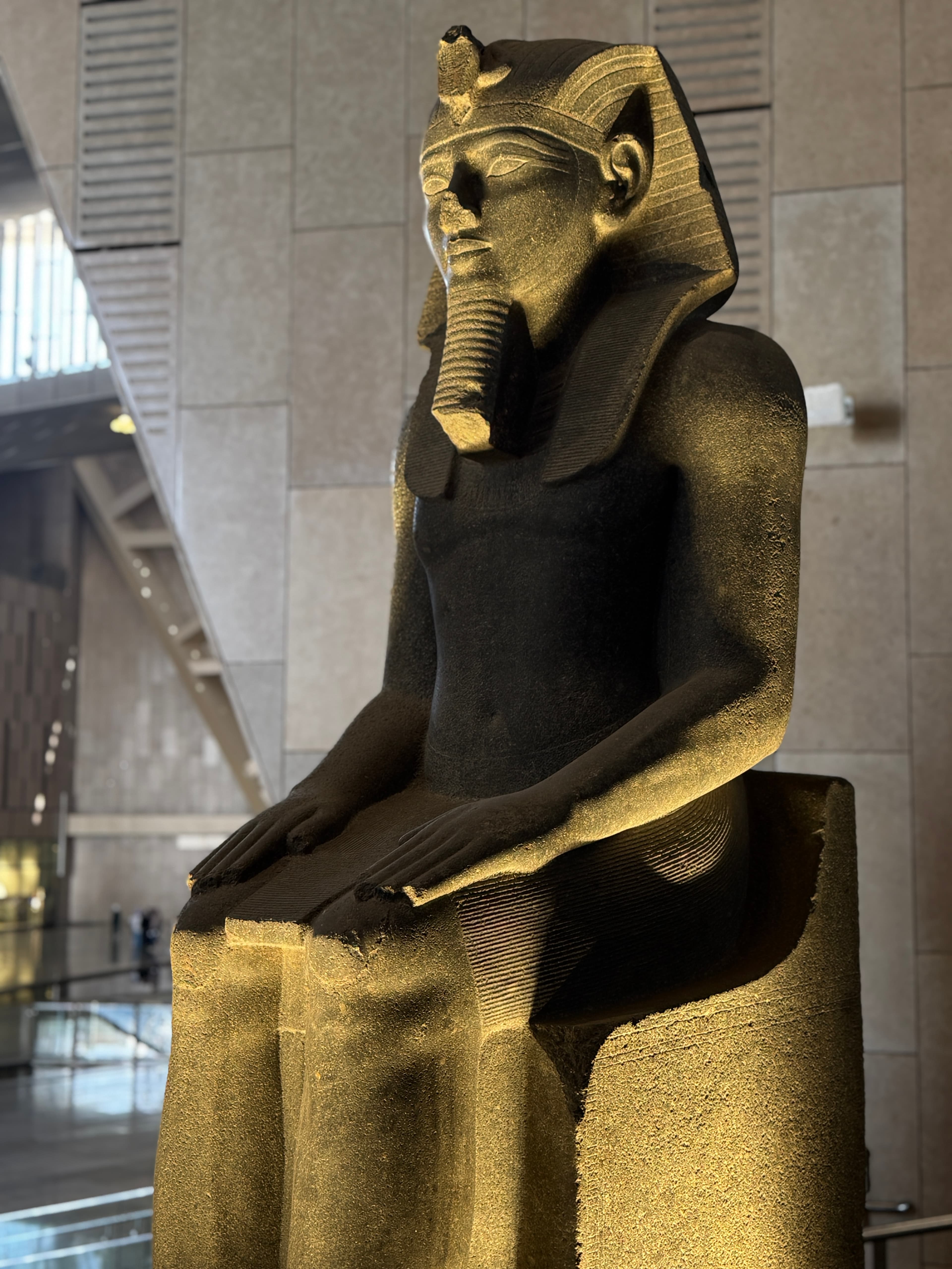 Seated ancient Egyptian statue in the Grand Egyptian Museum