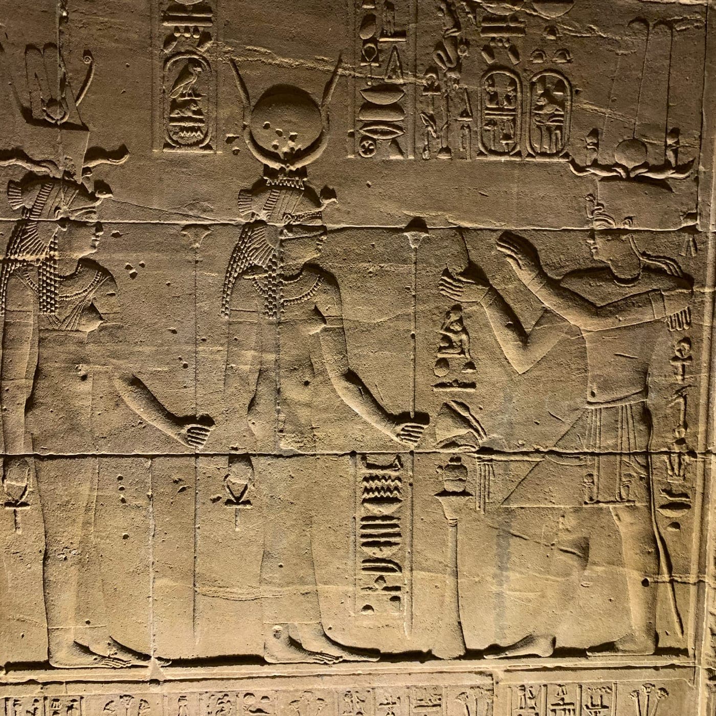 Close view of carved figures and hieroglyphs on a temple wall